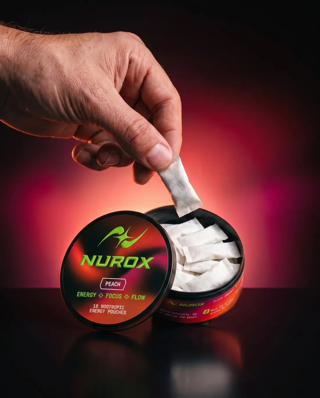 Hand taking a pouch from an open Nurox Peach tin